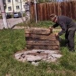 Еще один люк. Там же. Анатолий Юзюк показывает деревянный щит, который соорудили сами местные жители, чтобы закрыть колодец. 