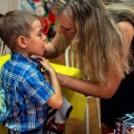 Лариса Попандопуло помогает сыну Данилу  с пуговицами на рубашке. Фото: Вадим Аминов, "ВК"